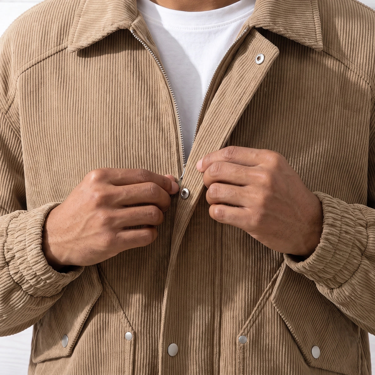 Man fastening a snap on the front of the tan corduroy jacket, close chest view