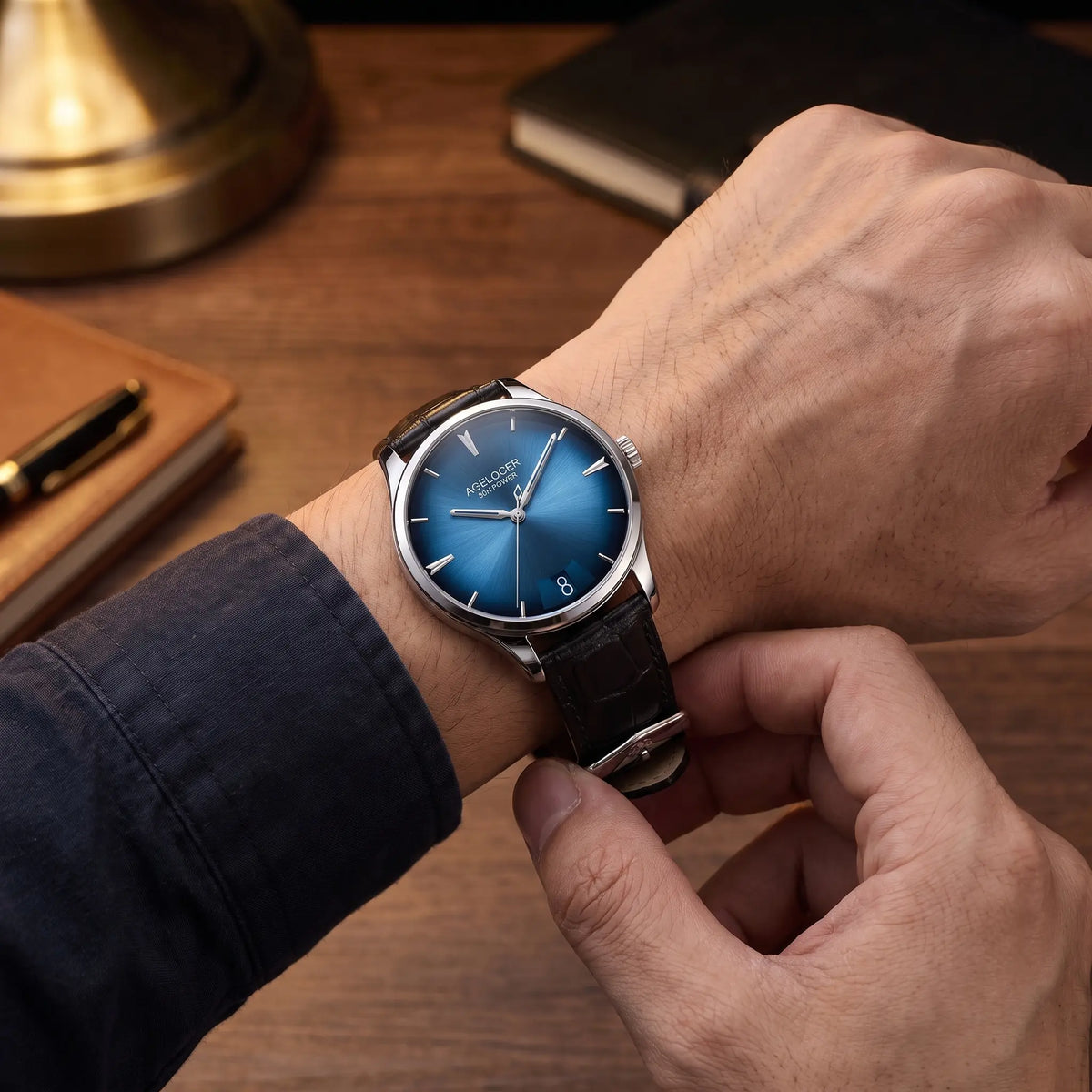 Man fastening the blue dial automatic dress watch onto his wrist