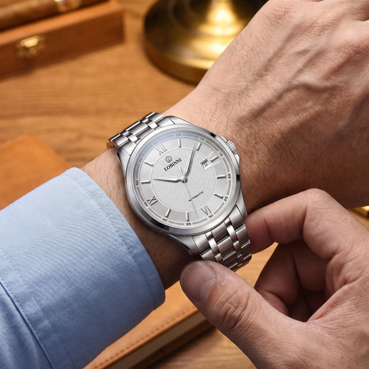 CLASSIC STEEL AUTOMATIC White Silver worn - man fastening the steel bracelet of the automatic watch on his wrist