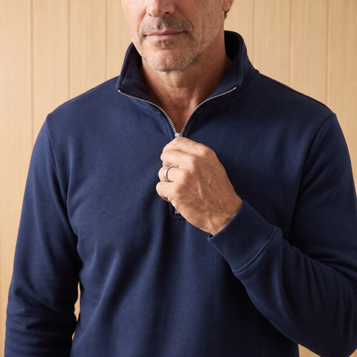 Man zipping up the navy blue classic zip neck sweatshirt