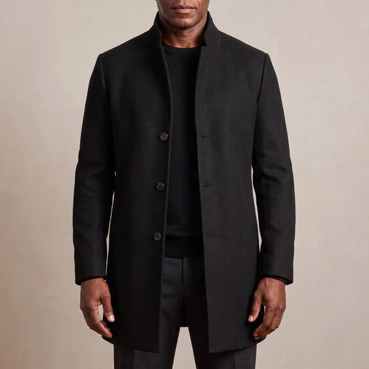 Black funnel neck wool overcoat worn open over a black tee