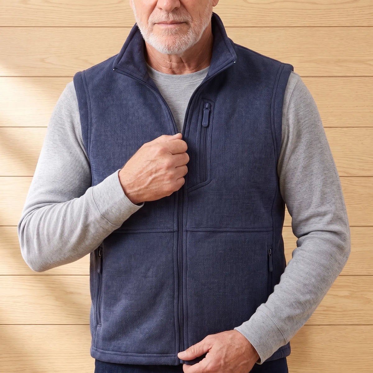 Man zipping up the HEATHER FLEECE VEST in navy blue
