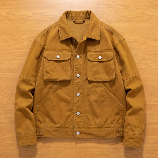 Khaki heavy canvas trucker jacket laid flat on an oak workbench