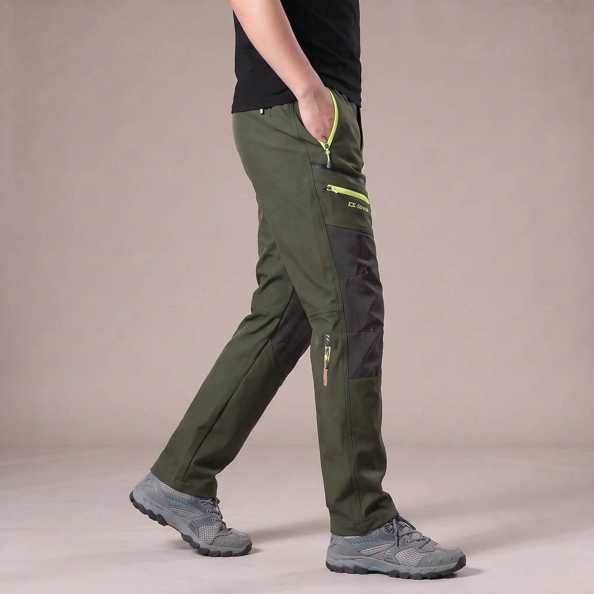 Side view of man walking in green knee panel hiking trousers