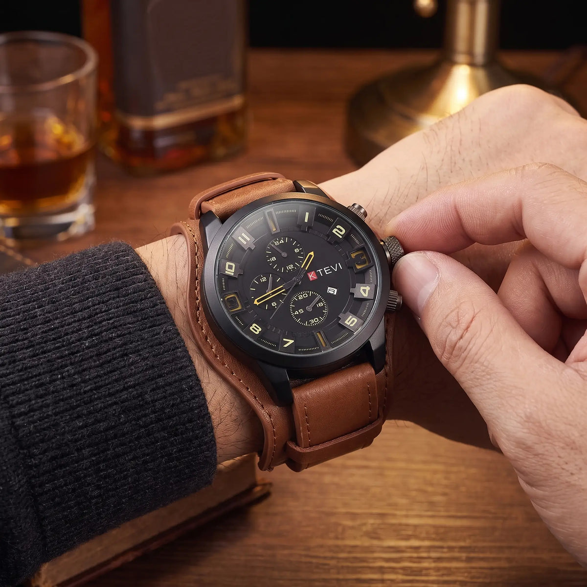 Man setting the time on the LEATHER CUFF WATCH in brown
