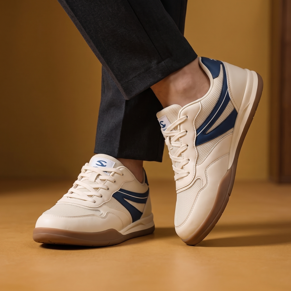 Man wearing the Lightweight Wide Toe Trainers with charcoal trousers, ankles crossed