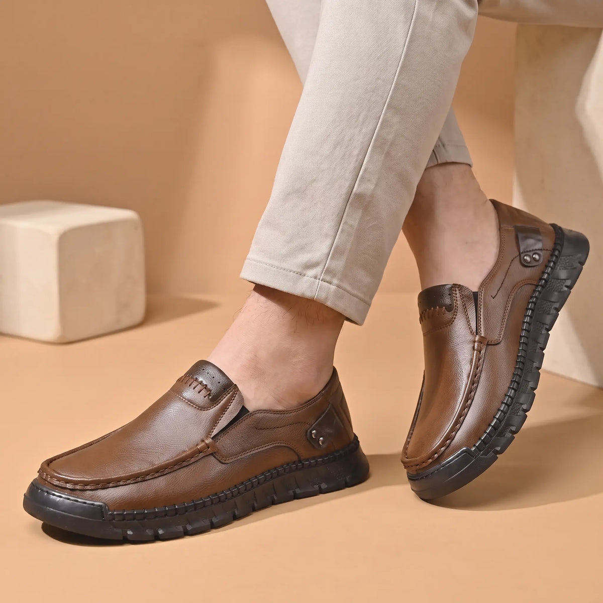 Pebble Moc Loafers in Brown worn as a pair with stone chinos