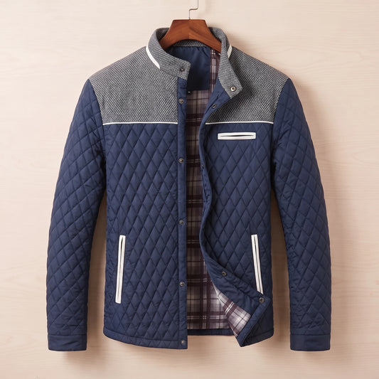 Navy blue diamond quilted jacket with tweed shoulder yoke on a wooden hanger