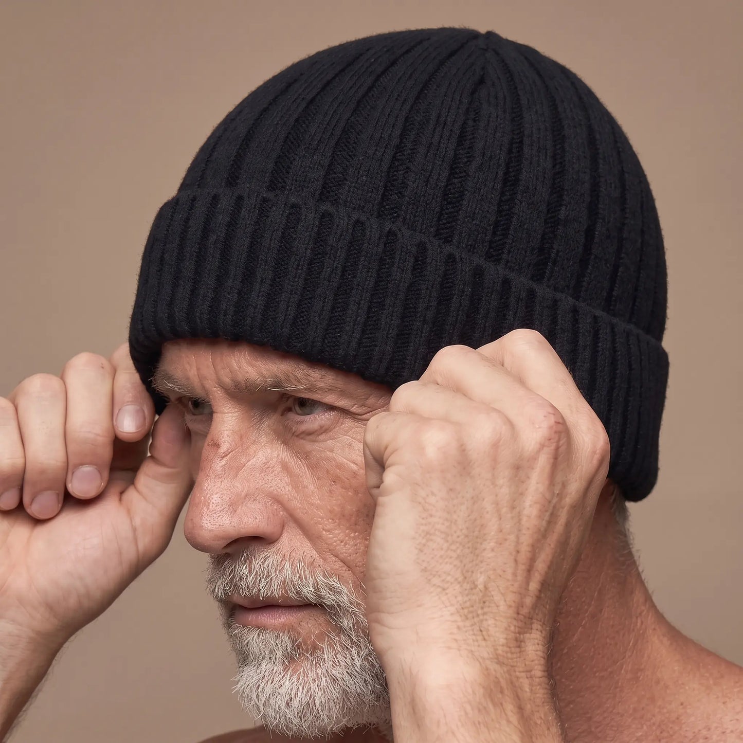 Older man pulling the ribbed docker beanie onto his head