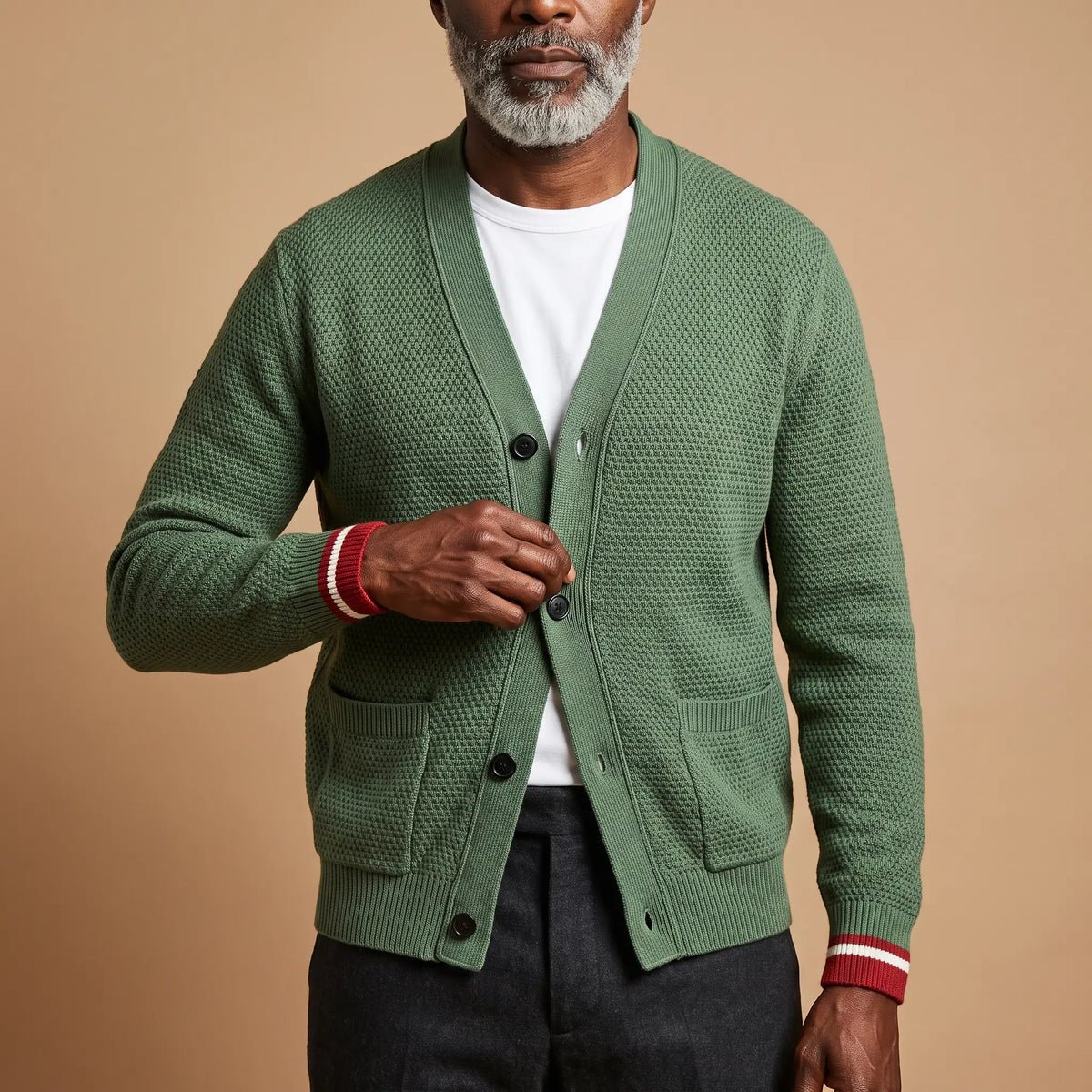 Man buttoning the green Stripe Cuff Cardigan over a white tee, men's textured knit cardigan with patch pockets