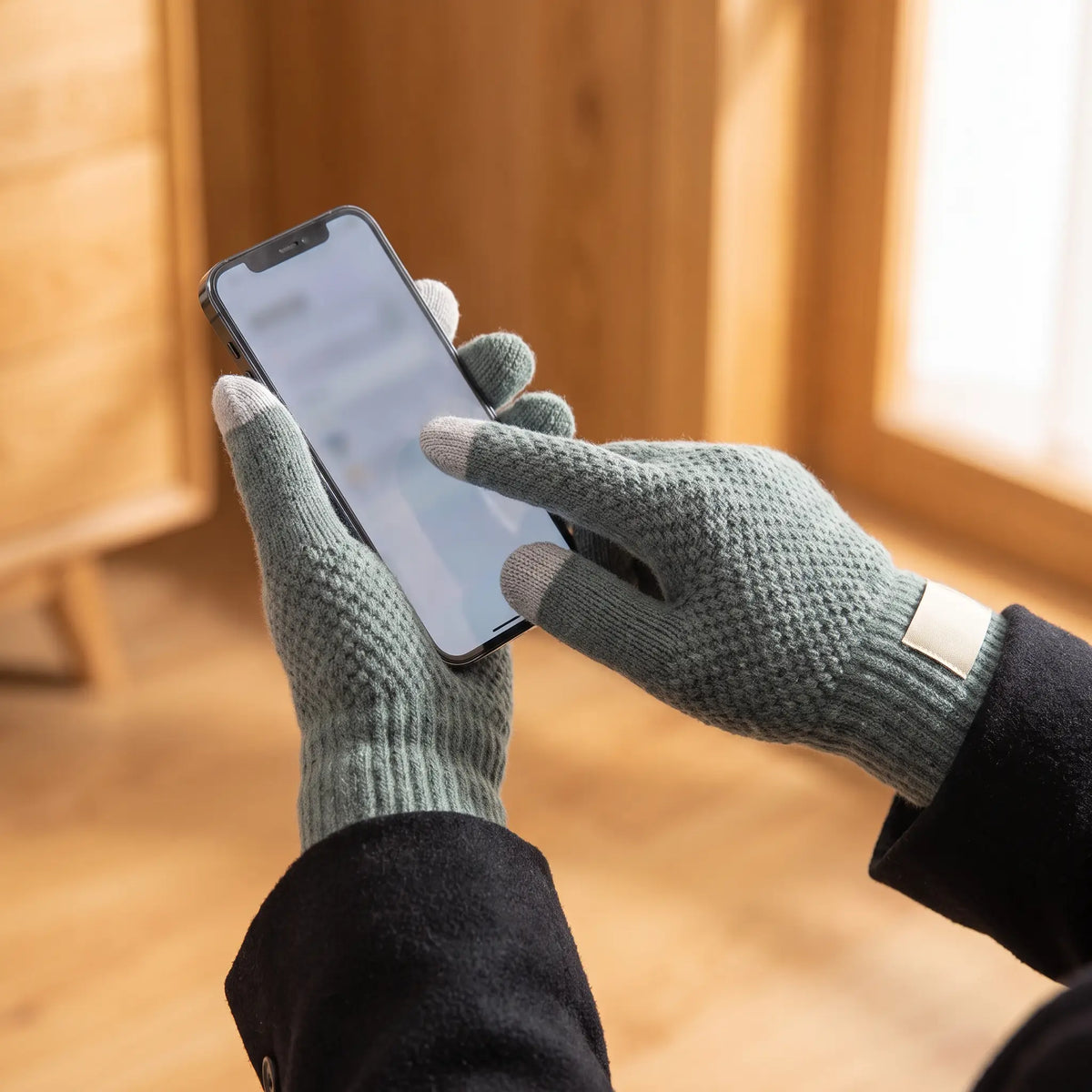 Touchscreen Knit Gloves in Green worn while using a phone