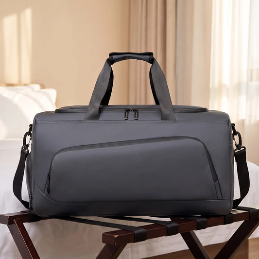 Transit gym duffel in dark grey on a wooden luggage rack in a hotel room