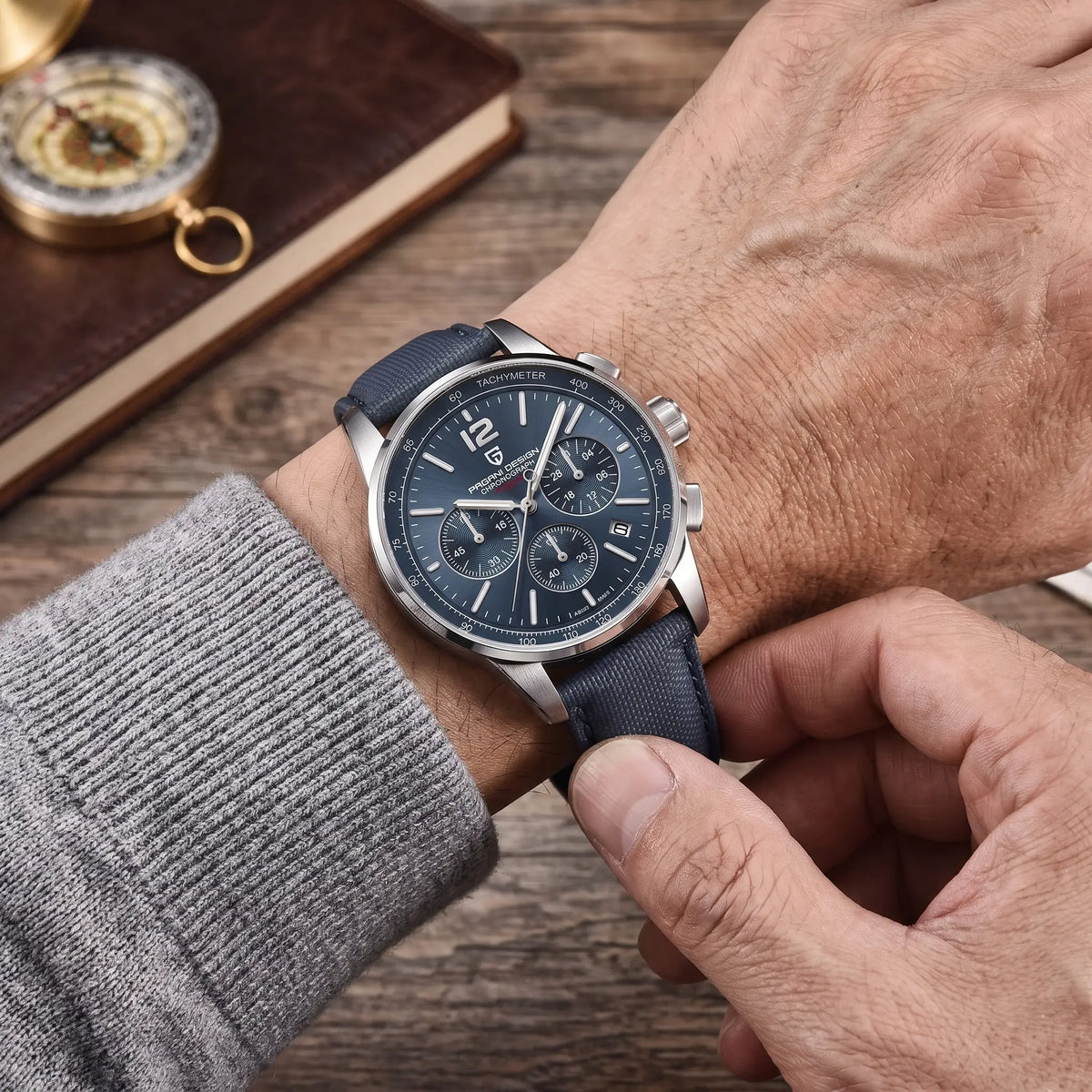 WOVEN STRAP CHRONOGRAPH Silver Blue worn - man fastening the woven strap of the chronograph on his wrist