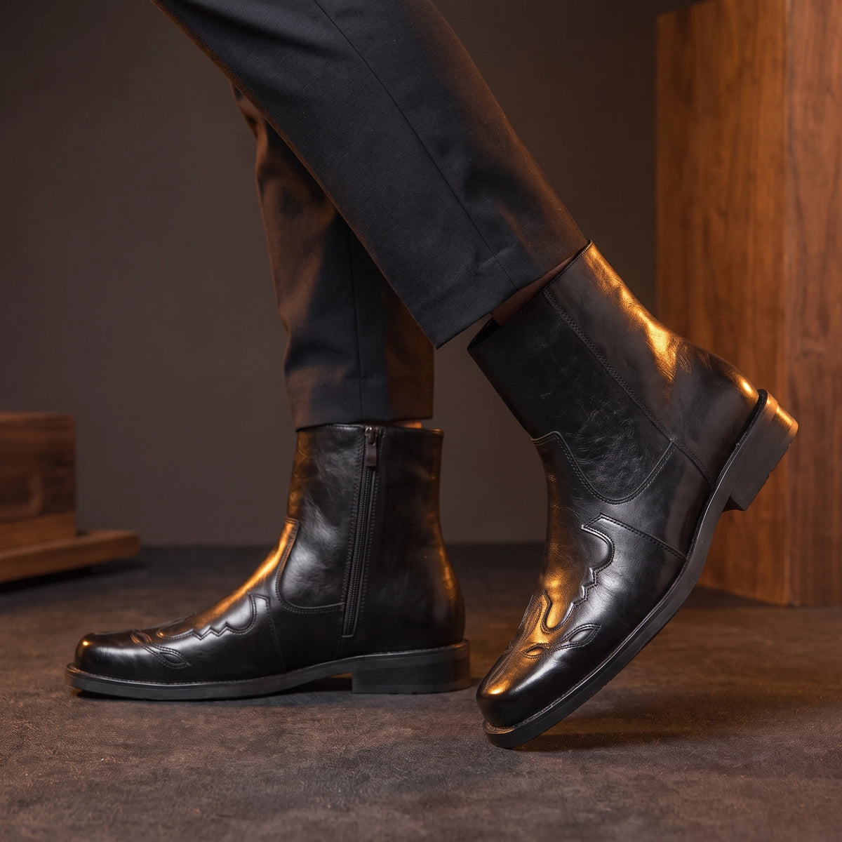 Man wearing black leather pointed Chelsea boots mid-stride