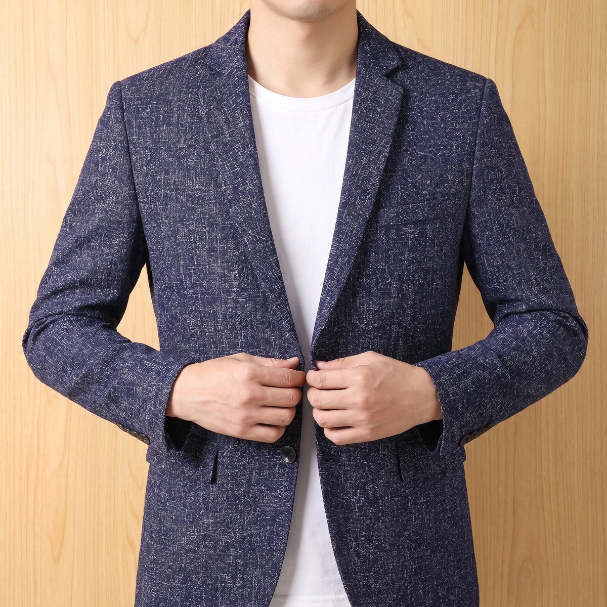 Man wearing tailored slim blazer, buttoning gesture