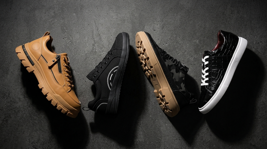 Four chunky men's sneakers on dark charcoal concrete