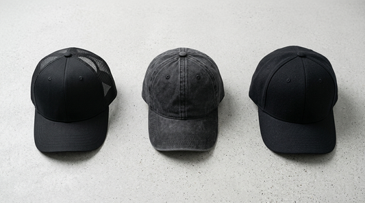 Trucker cap, dad cap and baseball cap side by side on grey concrete