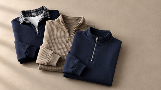 Three Adam & Westcott sweatshirts folded flat: a navy shirt-collar half zip, a khaki waffle quarter zip and a navy stand-collar zip neck