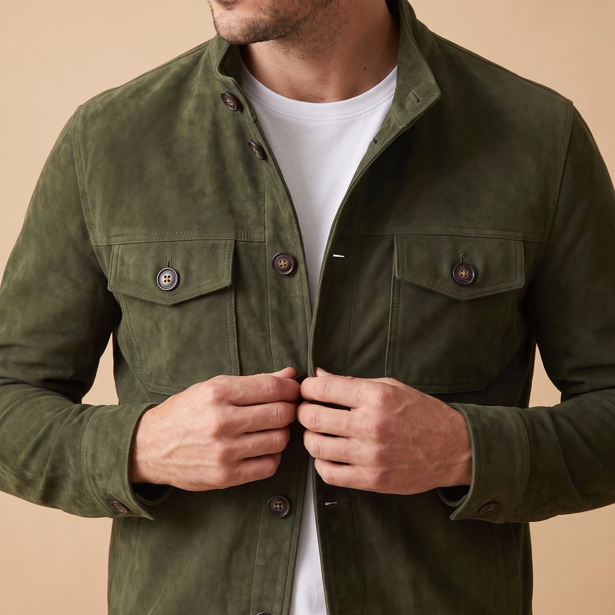 REFINED CHORE JACKET army green suede jacket worn, close-up of a man fastening the front placket button, two chest flap pockets