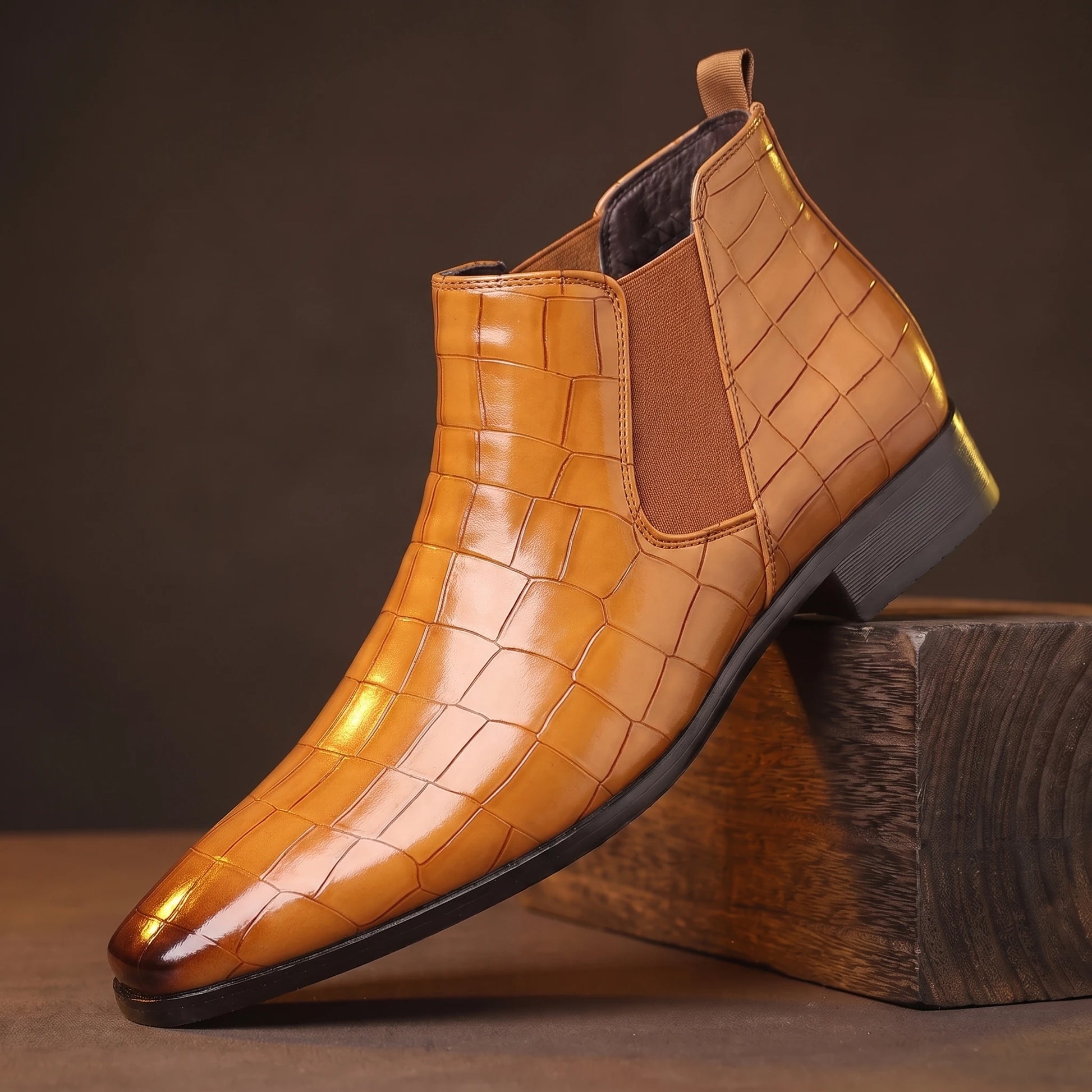 CROC GRAIN BOOTS camel croc-texture platform Chelsea boot on a smoked-oak block, moody amber light