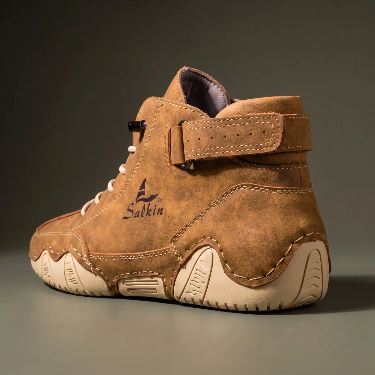 Close-up of the padded ankle collar, strap tab and heel on the tan brown ankle boot