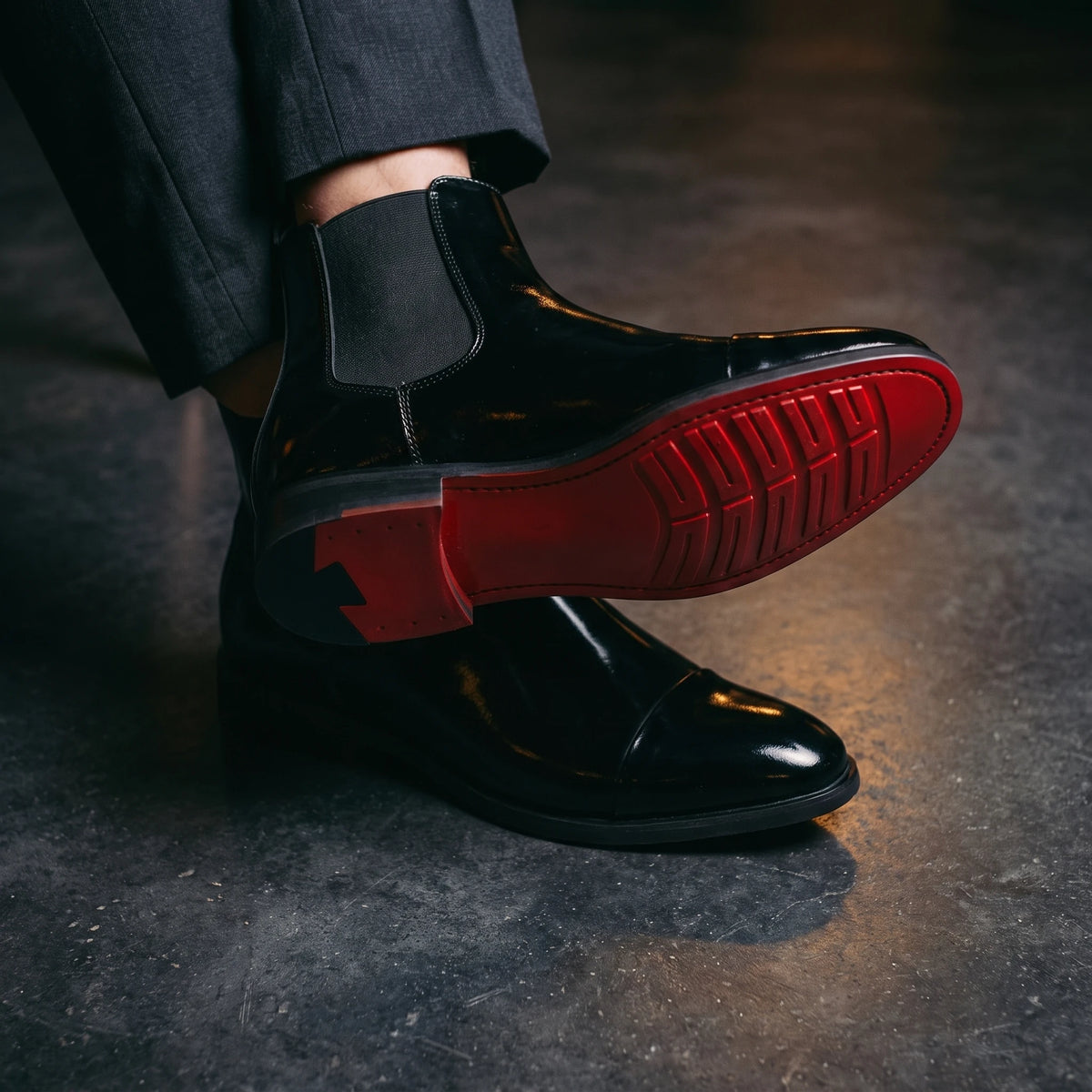 RED SOLE BOOTS worn, crossed ankles showing the red sole of the black patent boots, moody charcoal interior