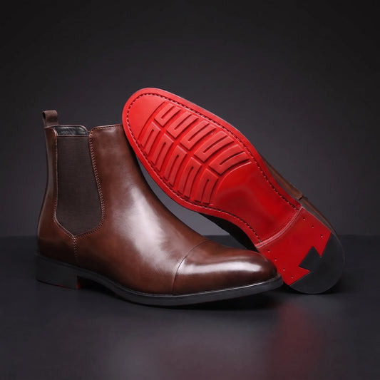 RED SOLE BOOTS brown leather Chelsea boot propped toe-up showing the detailed red lugged sole, dark charcoal scene
