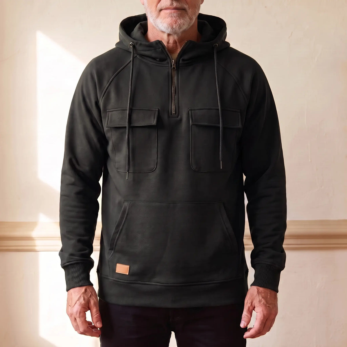 Men's black hooded anorak sweatshirt with half zip and twin chest flap pockets, worn