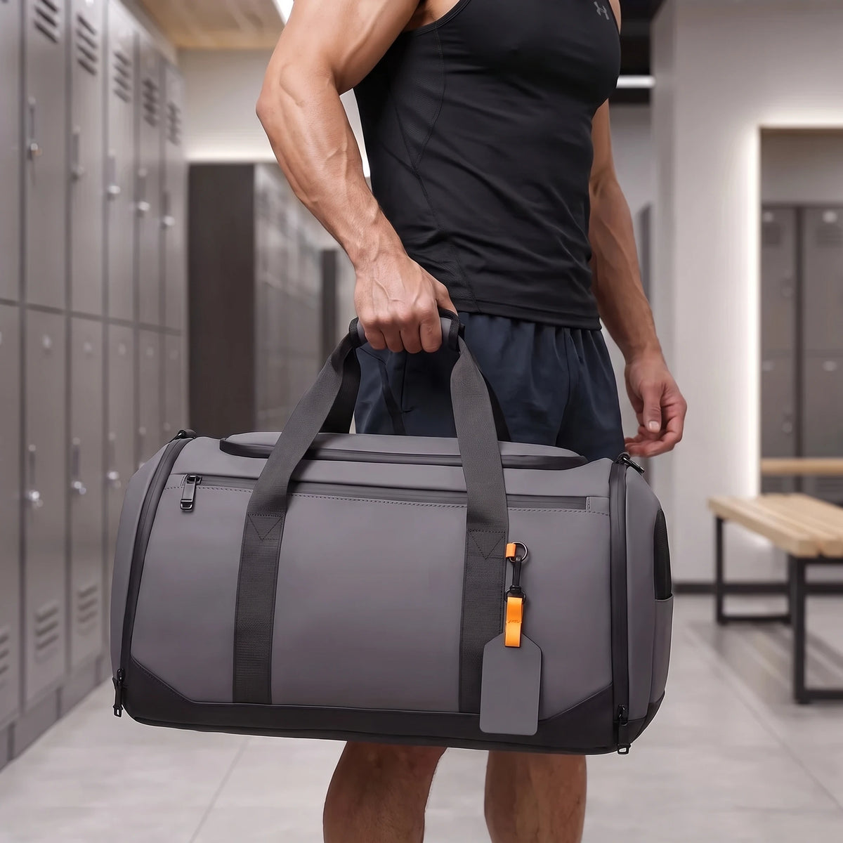 Athletic man carrying the gray gym duffel in a locker room