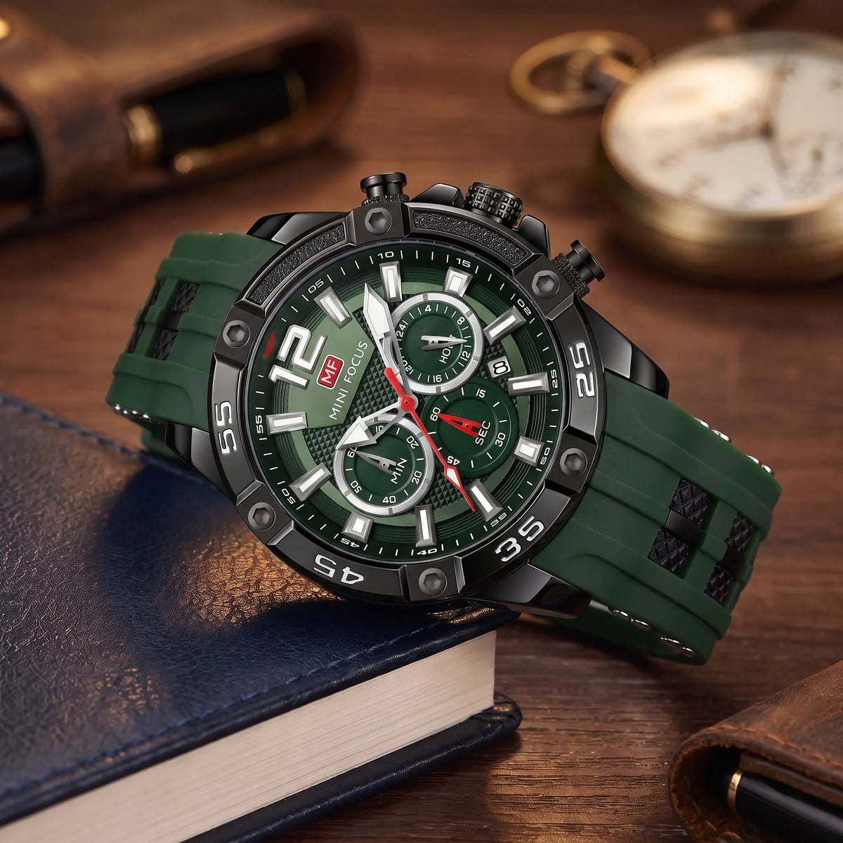 Men's green sport chronograph watch with screw-set black bezel and green silicone strap, resting on leather-bound books
