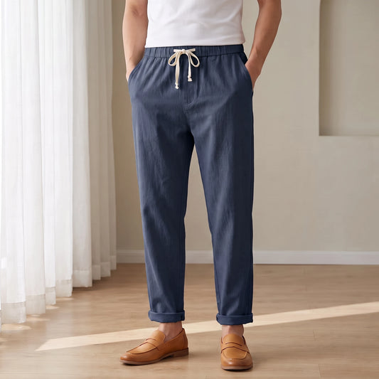 Drawstring cotton linen trousers in navy, worn in a bright airy room