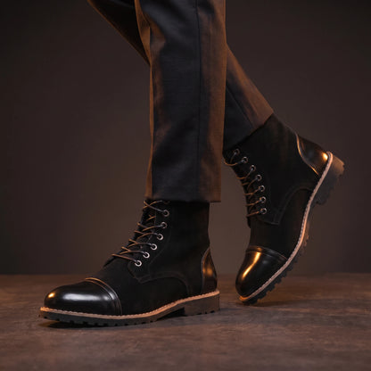 Man wearing black glossy leather ankle boots mid-stride