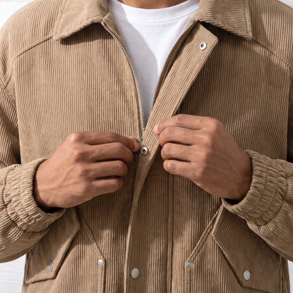 Man fastening a snap on the front of the tan corduroy jacket, close chest view