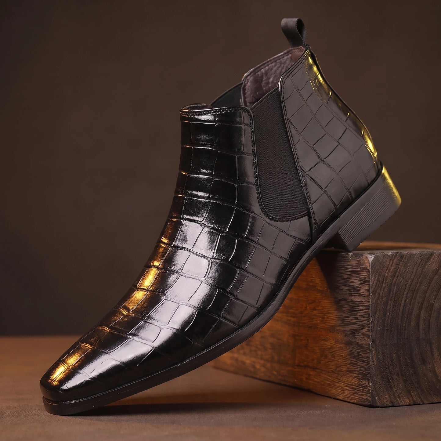CROC GRAIN BOOTS black croc-texture platform Chelsea boot on a smoked-oak block, moody amber light