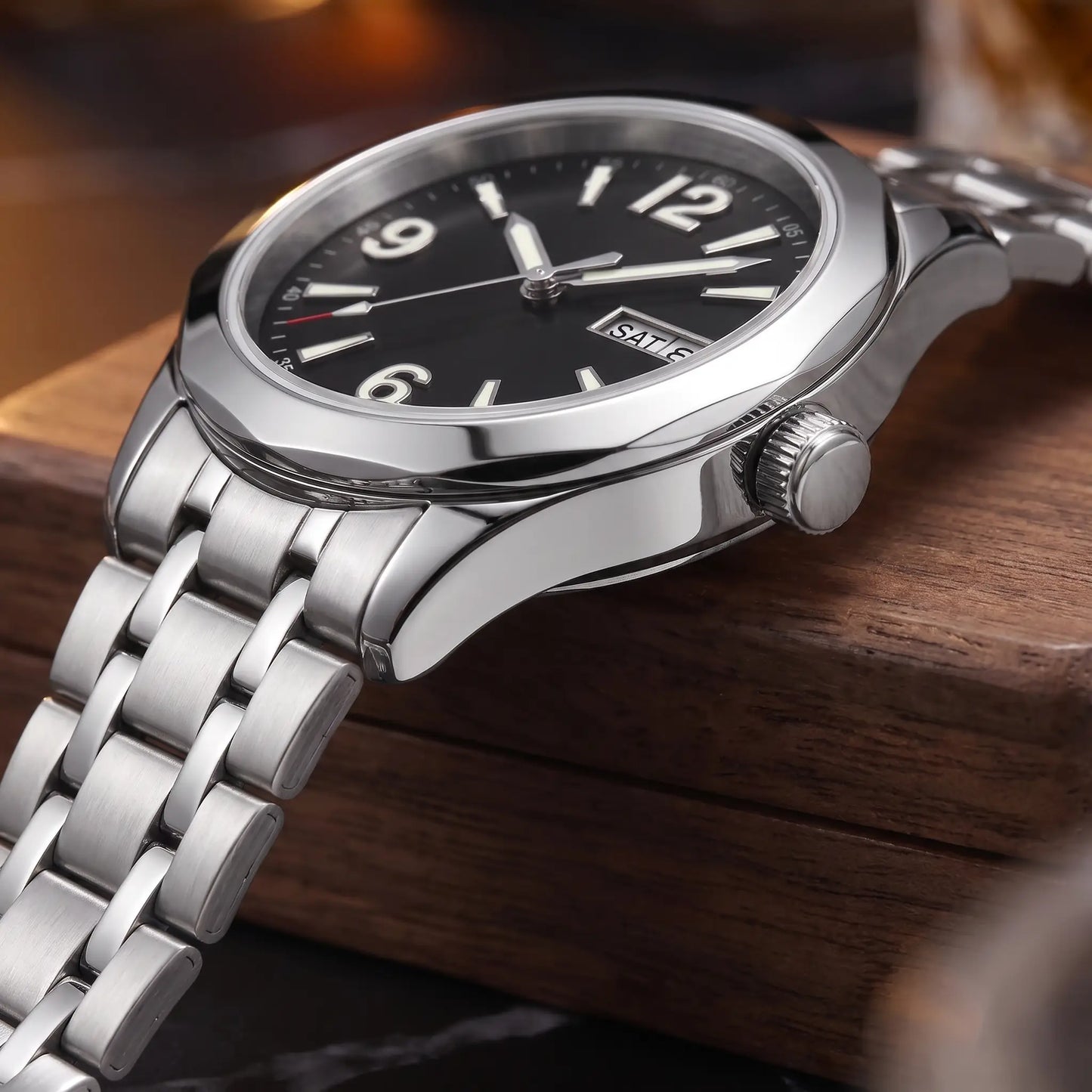 APPLIED NUMERAL WATCH case close-up - knurled crown, polished case side and multi-link steel bracelet