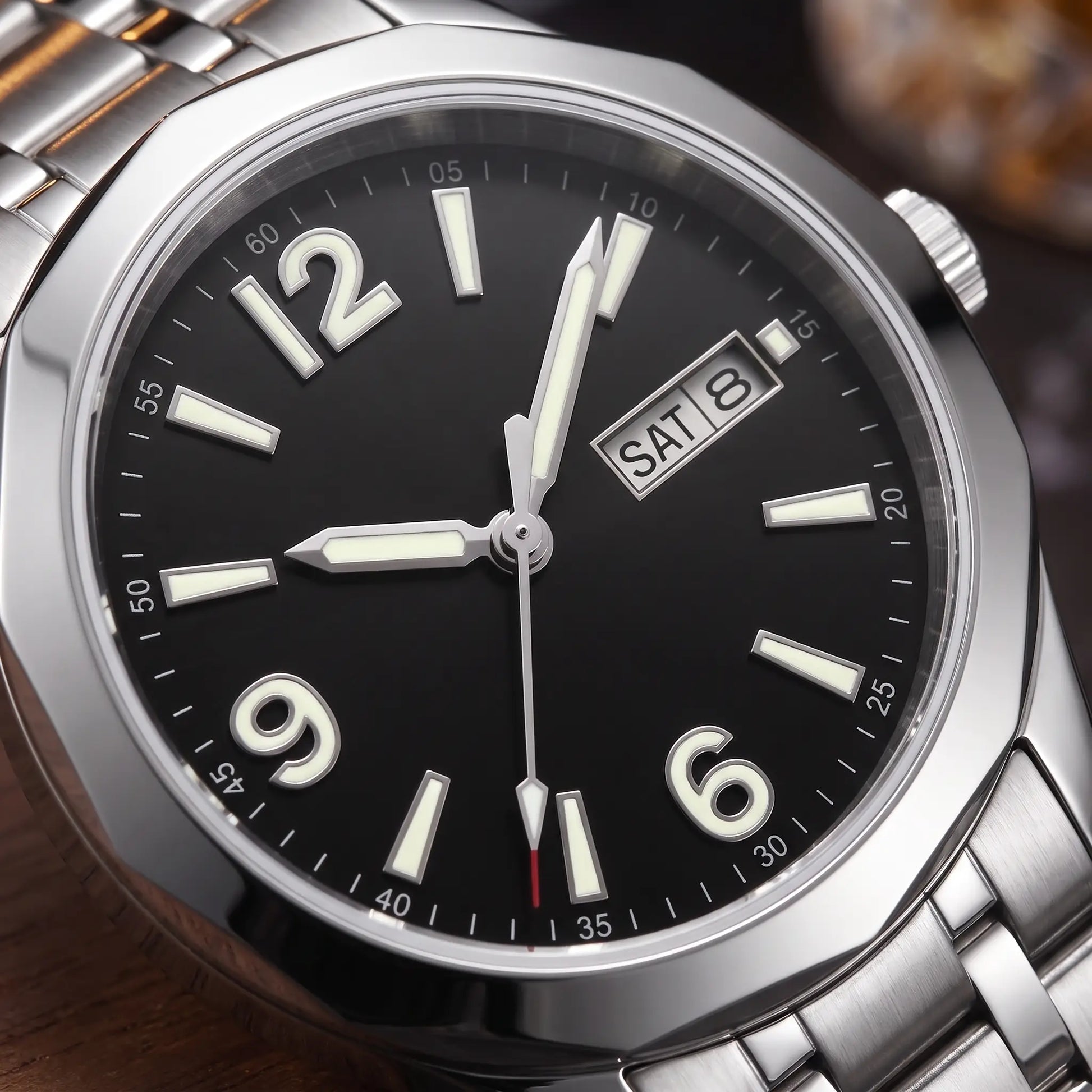 APPLIED NUMERAL WATCH dial close-up - applied glowing numerals and twin day-date window on the black dial