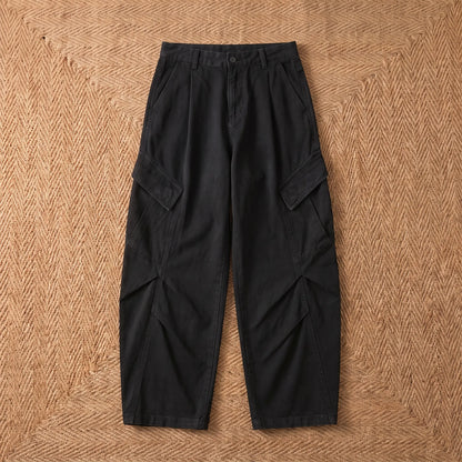 Baggy cargo trousers in washed black cotton laid flat on a jute rug