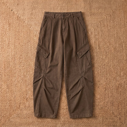 Baggy cargo trousers in washed brown cotton laid flat on a jute rug