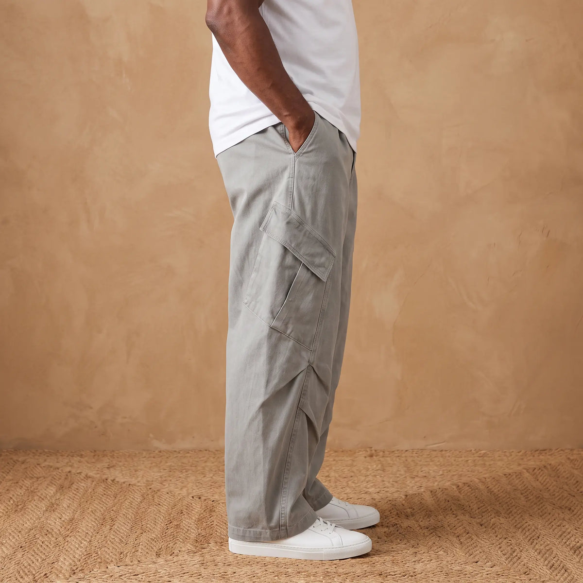 Side view of a man wearing the grey baggy cargo trousers