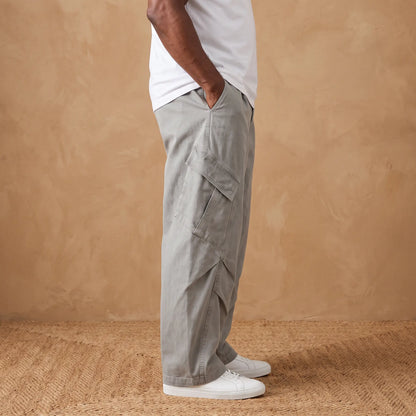Side view of a man wearing the grey baggy cargo trousers