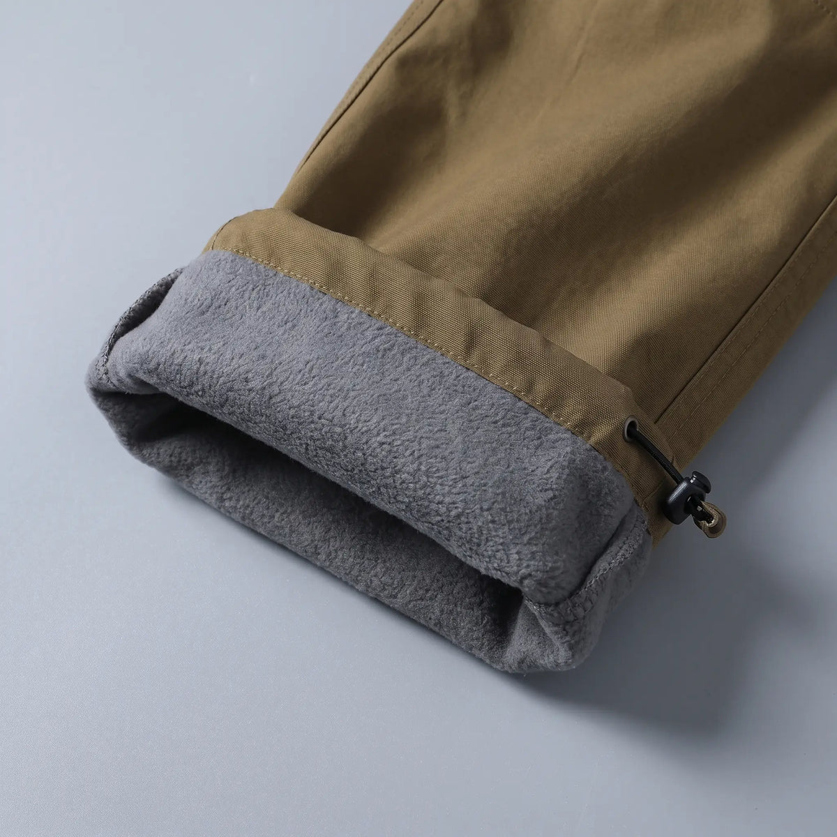 Close up of the BELTED OUTDOOR TROUSERS grey fleece lining and drawcord hem