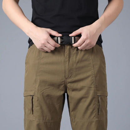 Man fastening the buckle on the BELTED OUTDOOR TROUSERS in brown