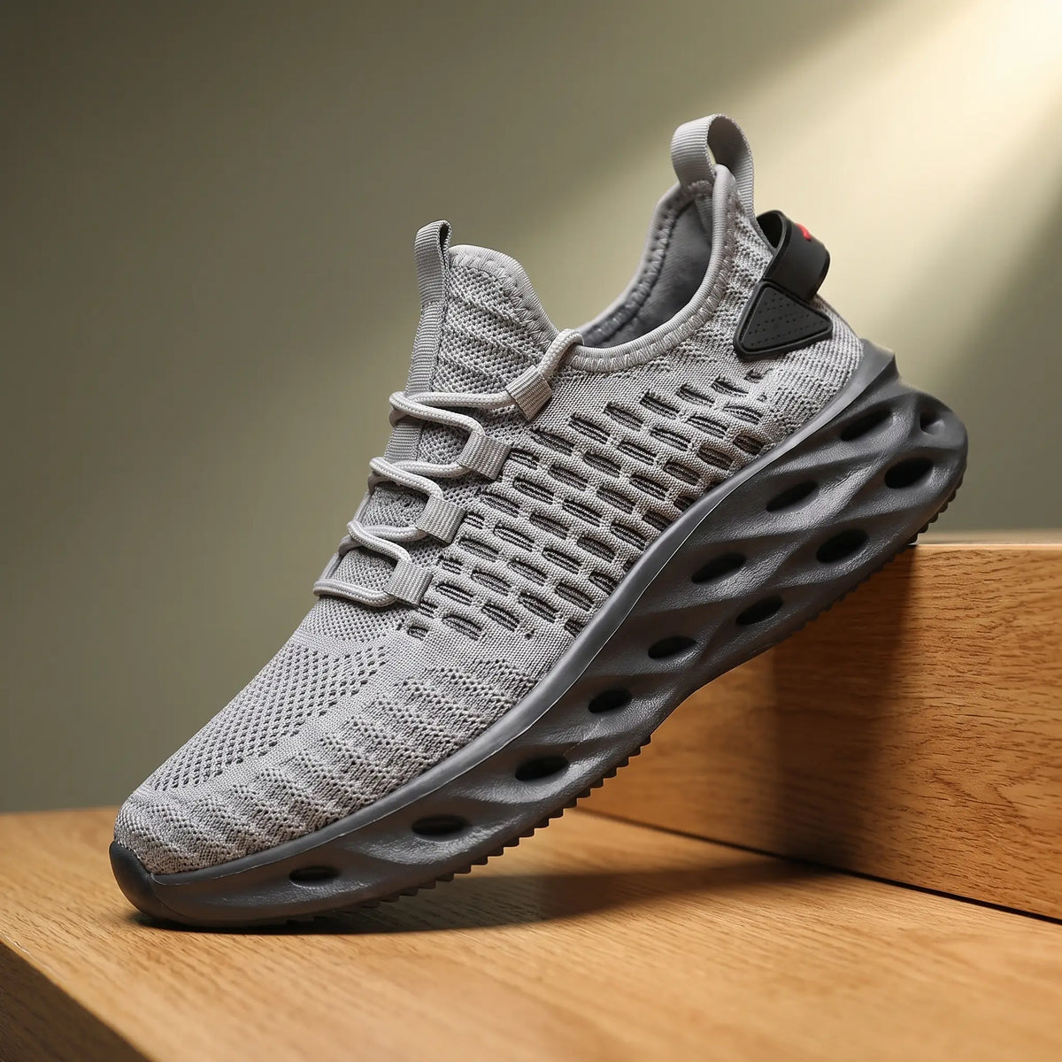 Grey knit running sneakers with a thick blade cutout sole