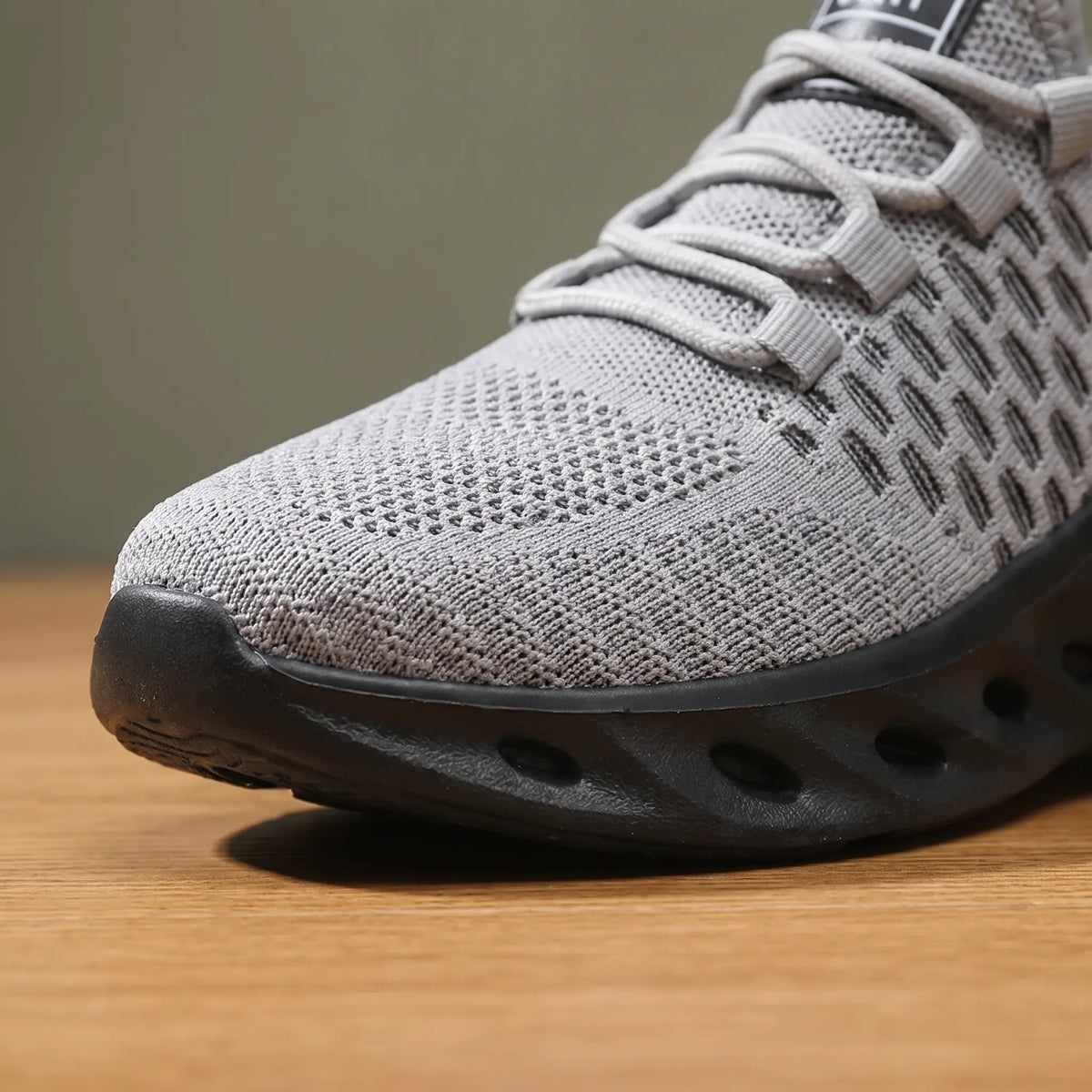 Front close up of grey knit sneakers showing the honeycomb knit and sole cutouts