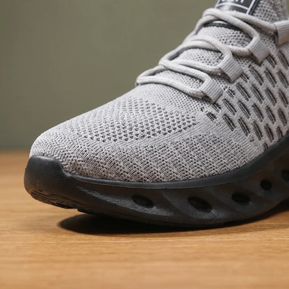Front close up of grey knit sneakers showing the honeycomb knit and sole cutouts