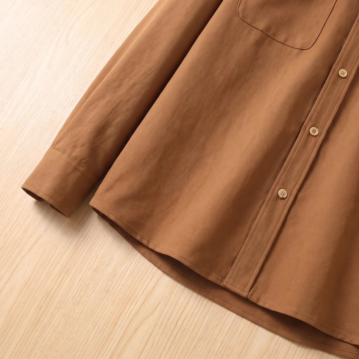 Side view of the cuff, button placket and straight hem on the brown Boxy Cotton Overshirt