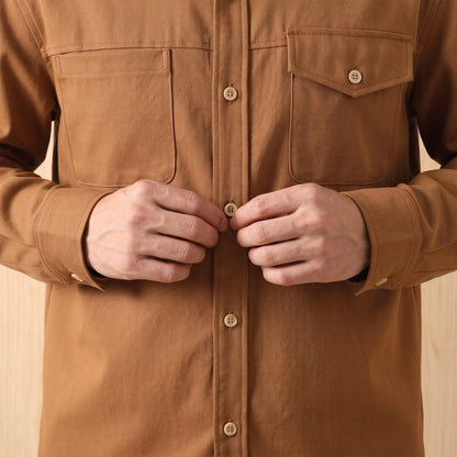 Man buttoning up the brown Boxy Cotton Overshirt