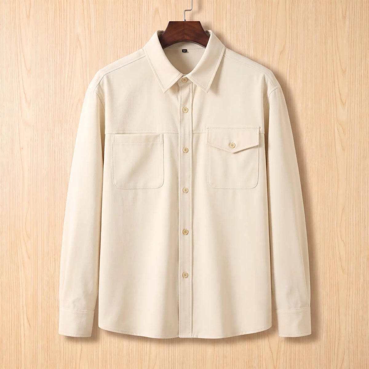 Boxy Cotton Overshirt in white, a loose fit utility overshirt with asymmetric chest pockets on a wooden hanger