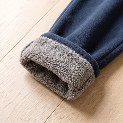 Rolled cuff of navy blue fleece trousers showing grey sherpa lining