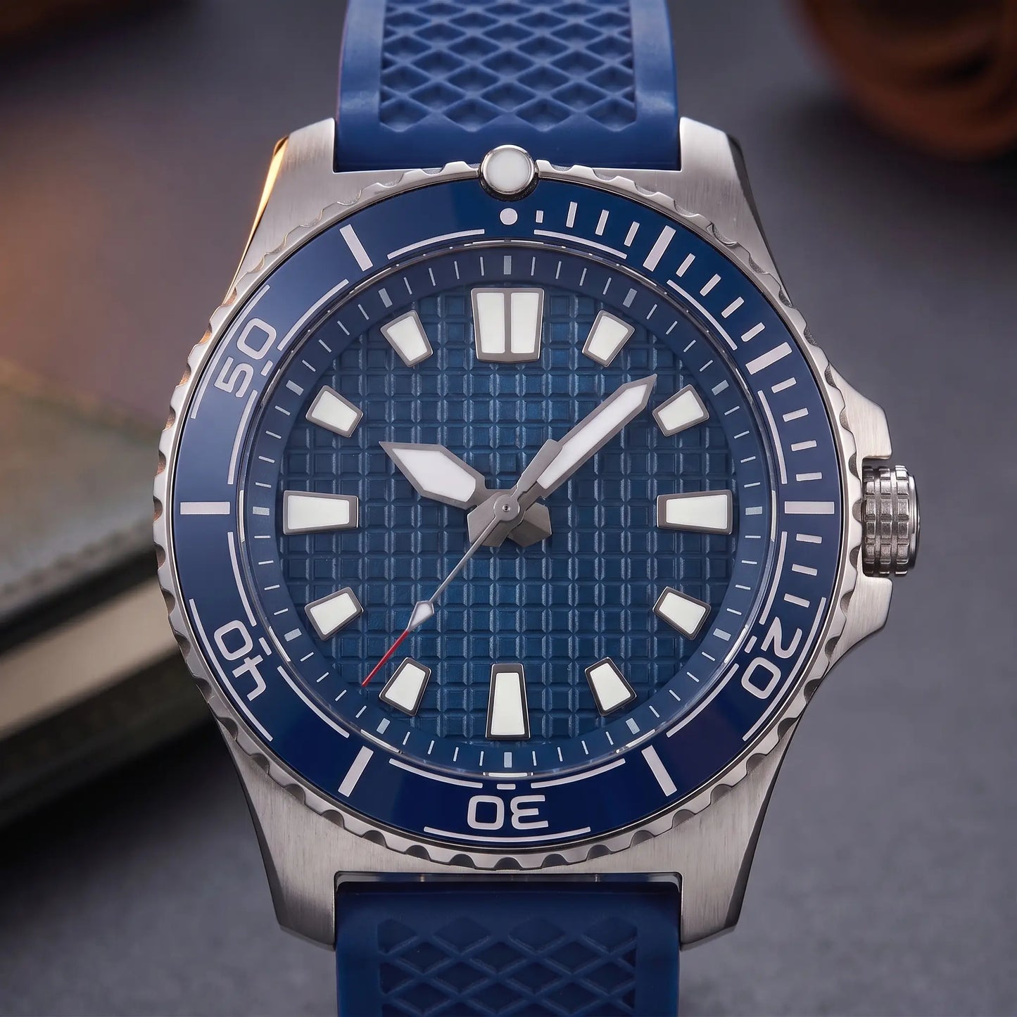 CERAMIC BEZEL WATCH dial close-up - blue waffle-textured dial with luminous baton markers and ceramic dive bezel